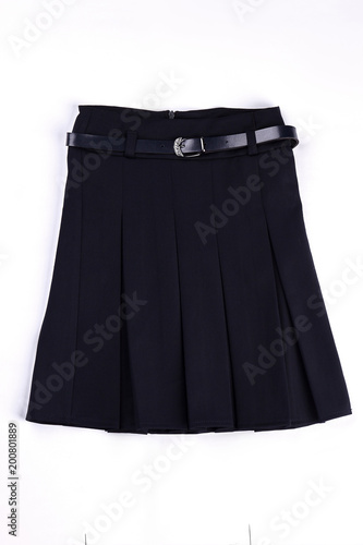 Pleated black uniform skirt isolated. Girls beautiful belted black skirt on white background. Classic pleated skirt with a belt.