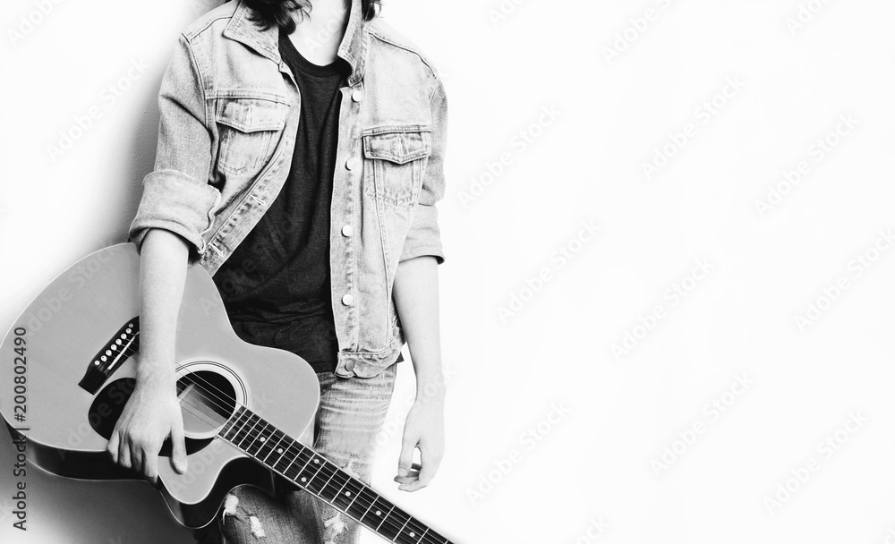 Teenager in white background holding his guitar Teenager in white background holding his guitar