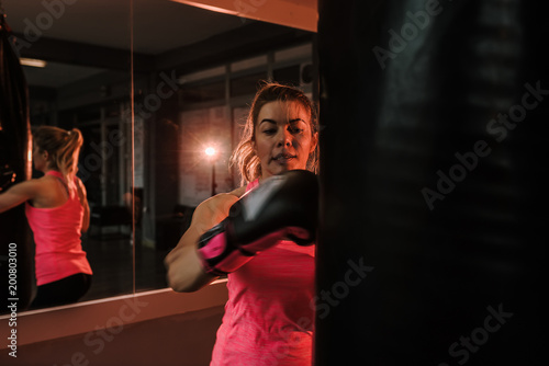 Woman punching into bag at the gym. © bnenin