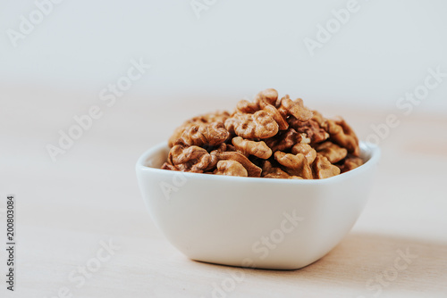 Walnuts kernel in a ceramic white bowl.