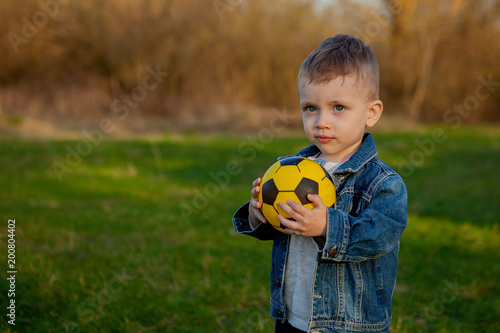 two-old years boy keeping soccer ball in park