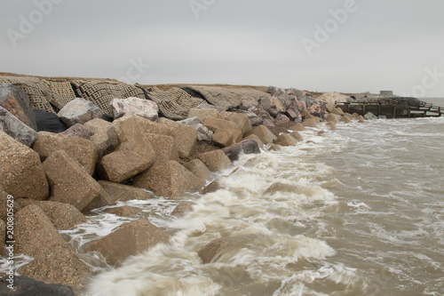 Coastal erosion along the sea wall at Aldeburgh where the North sea has nearly breached the defences and joined up with the river Alde photo