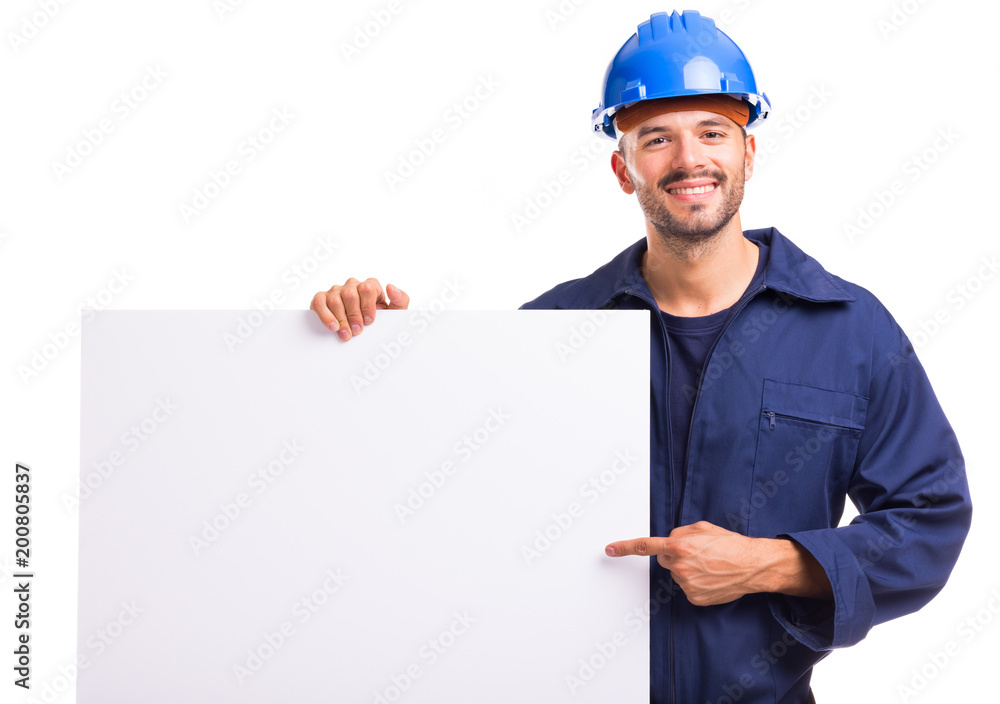 Smiling young worker pointing to a white placard ready for your text or product Smiling young worker pointing to a white placard ready for your text or product
