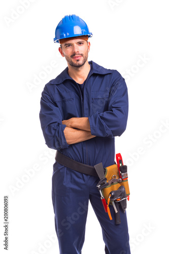 Portrait of a serious young worker standing with arms crossed on white background