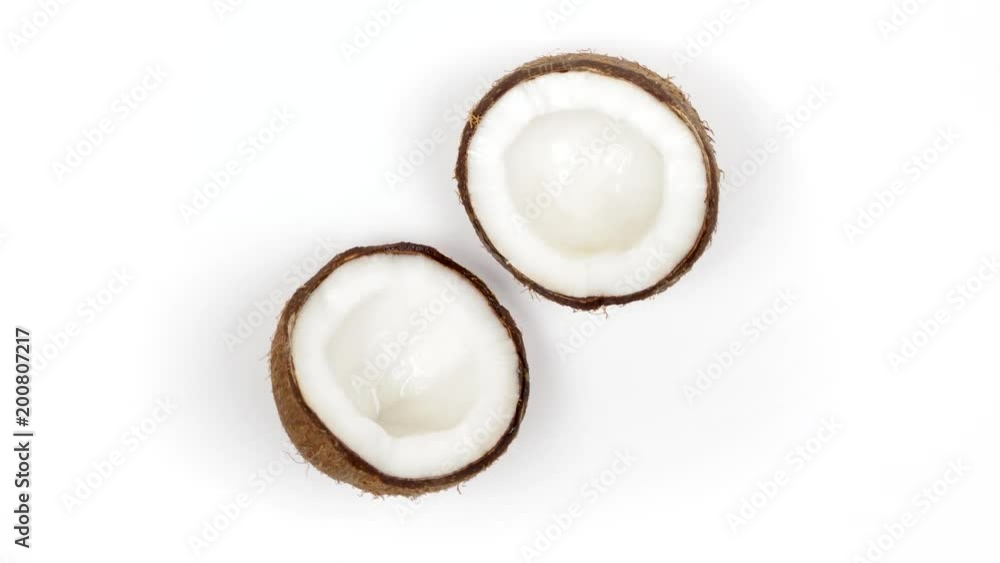 Top view of two ripe tropical coconut halves with yummy white pulp rotating on white isolated background. Healthy fresh tropical fruits. Loopable seamless cocos rotating Top view of two ripe tropical coconut halves with yummy white pulp rotating on white isolated background. Healthy fresh tropical fruits. Loopable seamless cocos rotating