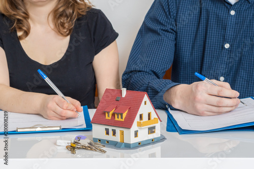 Divorce and dividing a property concept. Man and woman are signing divorce agreement.
