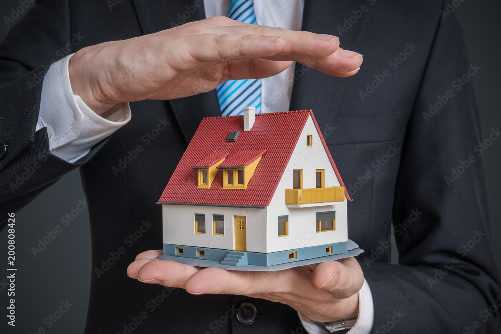 Home insurance concept. Man is holding model of house. Home insurance concept. Man is holding model of house.