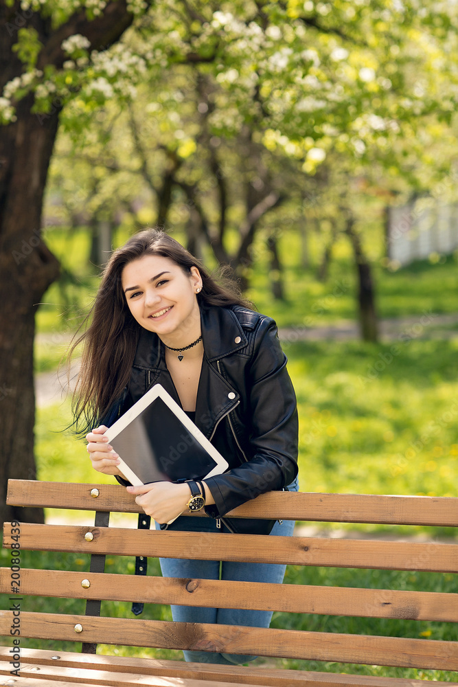 Young girl in the park with a tablet in hand. Young girl in the park with a tablet in hand.
