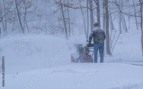A man is removing snow using snowblower