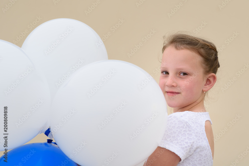 Little girl playing with balloons outdoor. Happy child wears white summer dress.Summer vacation,holidays, celebration, children and people concept. Little girl playing with balloons outdoor. Happy child wears white summer dress.Summer vacation,holidays, celebration, children and people concept.