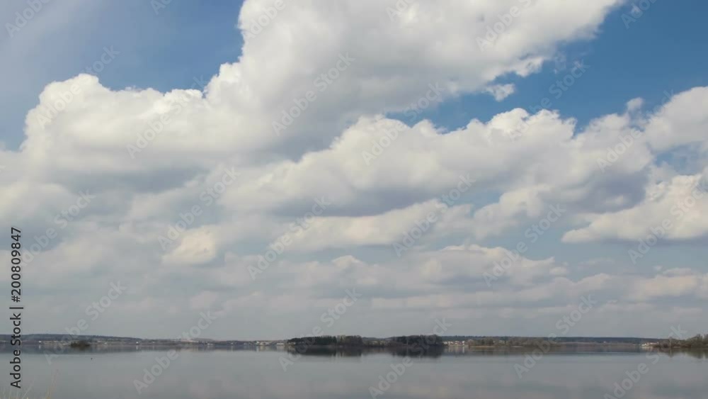Clouds  over  the lake, timelapse. The movement of clouds over a spring lake. 
