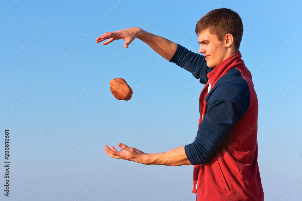 A young man with a stone, levitation. A young man throws stones.