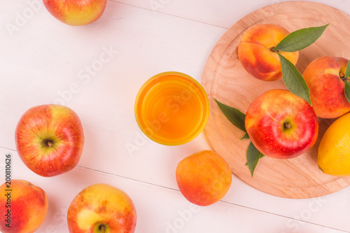 A glass of apple-peach detox on a rustic table with fresh fruit - top view