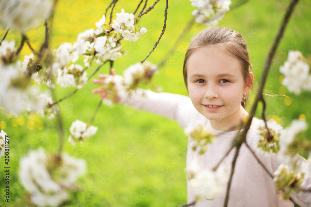 Adorable little girl in blooming cherry garden on beautiful spring day Adorable little girl in blooming cherry garden on beautiful spring day