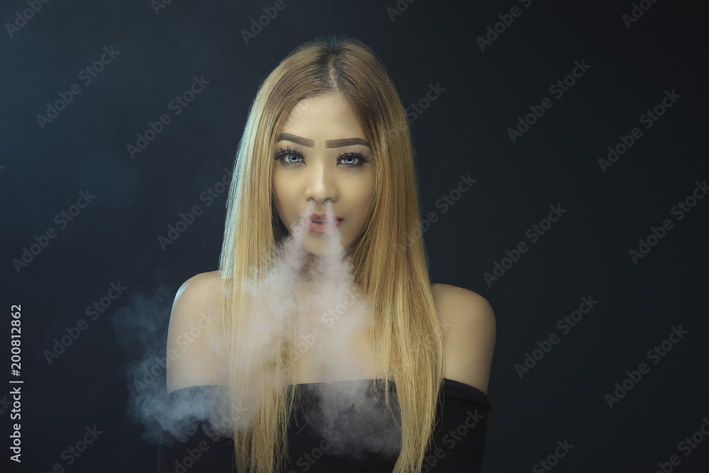 Young woman smoking electric cigarette