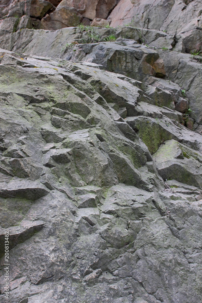 Granite rocks with faults, background of old stones, destruction of a granite wall, ecological problems of the planet Earth, climate change, natural pattern, art