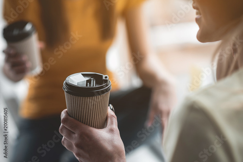 Foto Glad lady holding caffeinated beverage in her hand