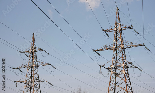 High-voltage towers, transmission line in sky background.