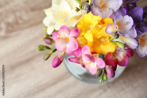 Beautiful bouquet of freesia flowers on table
