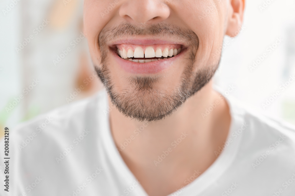 Young man with beautiful smile indoors. Teeth whitening Young man with beautiful smile indoors. Teeth whitening