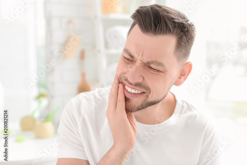 Quadro su tela Young man suffering from toothache indoors