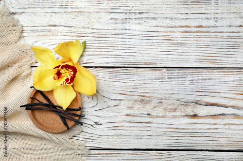 Vanilla flower and sticks on wooden background