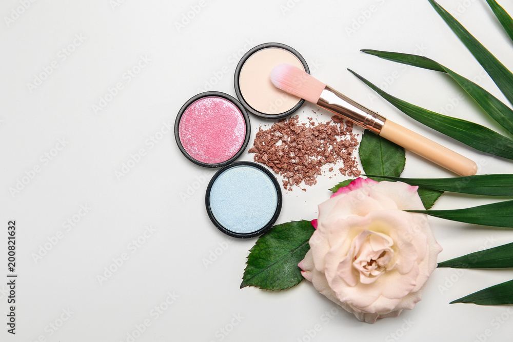 Flat lay composition with makeup brush, cosmetic products and rose on white background Flat lay composition with makeup brush, cosmetic products and rose on white background