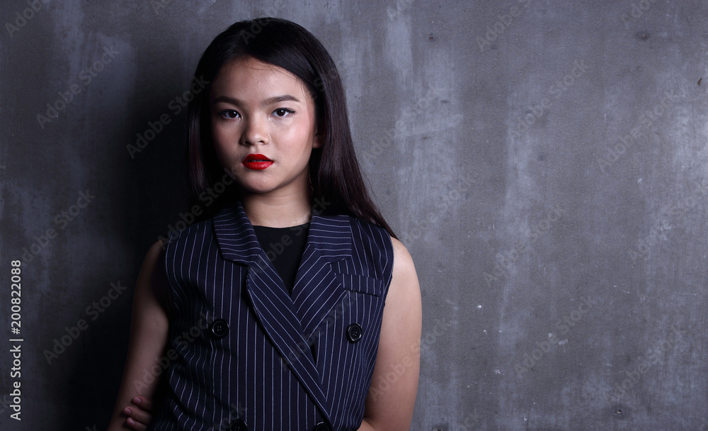 Business Kid Girl in formal suit stand on dark abstract background Business Kid Girl in formal suit stand on dark abstract background