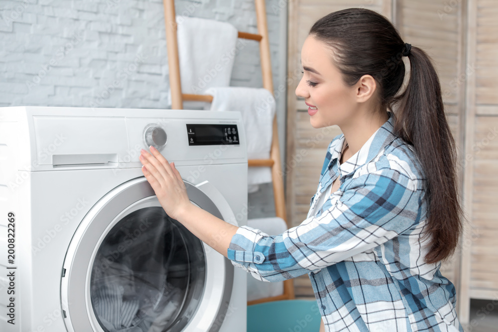 Young woman doing laundry at home Young woman doing laundry at home
