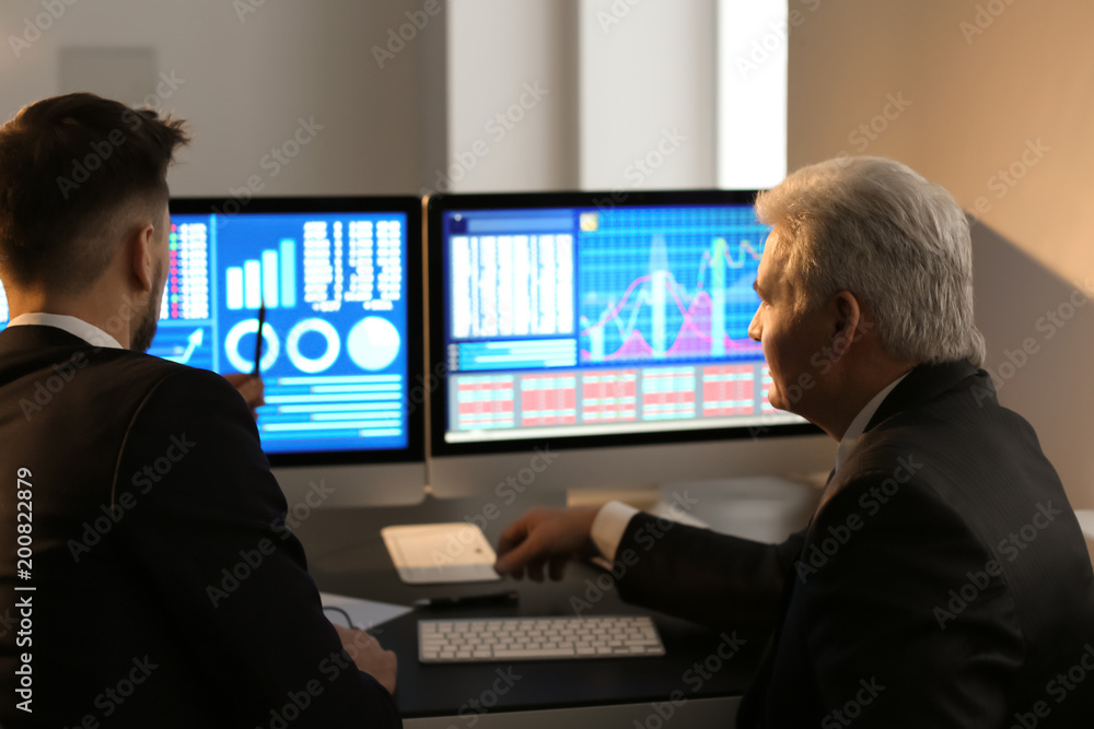 Male brokers working in office. Finance trading concept Male brokers working in office. Finance trading concept