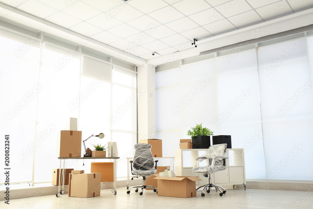 Moving boxes and furniture in new office - obrazy, fototapety, plakaty 