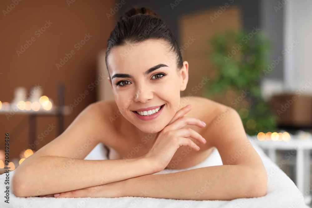 Young woman lying on massage table in spa salon Young woman lying on massage table in spa salon