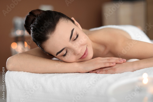 Young woman lying on massage table in spa salon