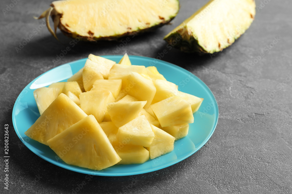 Plate with fresh sliced pineapple on table Plate with fresh sliced pineapple on table