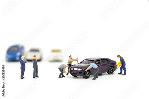 Miniature mechanics repairing toy car,concept of the workshop