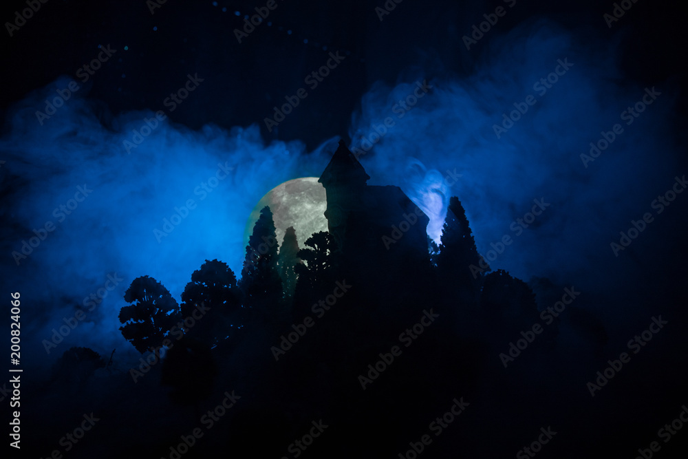 Old house with a Ghost in the forest at night or Abandoned Haunted Horror House in fog. Old mystic building in dead tree forest. Horror Halloween concept. Old house with a Ghost in the forest at night or Abandoned Haunted Horror House in fog. Old mystic building in dead tree forest. Horror Halloween concept.