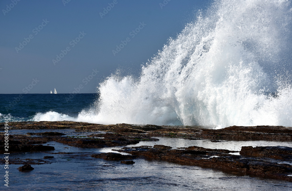 Splash in the shape of a wave and water flow at Narrabeen rock shelf at high tide