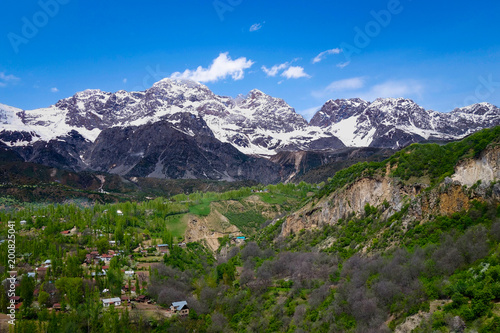 View over the town and walnut forests of Arslanbob village in southern Kyrgyzstan, with mountains in the background