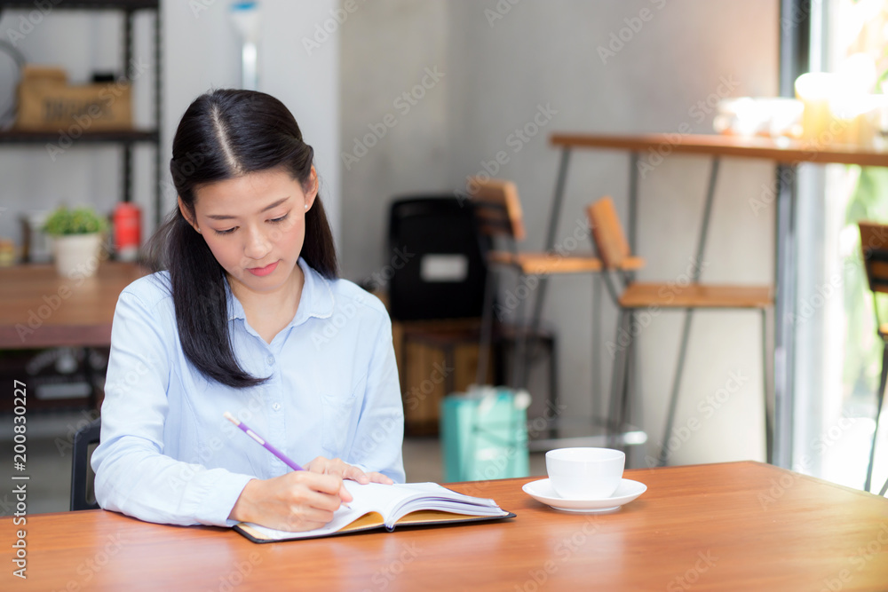 Beautiful business asian young woman writing on notebook on table, girl work at coffee shop, freelance business concept. Beautiful business asian young woman writing on notebook on table, girl work at coffee shop, freelance business concept.