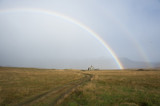Rainbow behind abandoned Iceland home in a field 