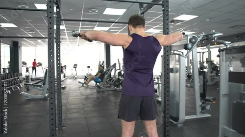 Sportsman lifting dumbbells sport club, lateral raise exercise, active leisure