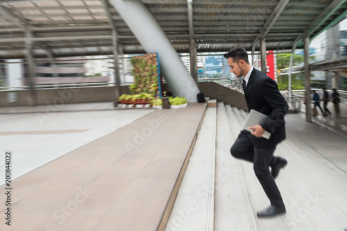 Businessman running in hurry at town