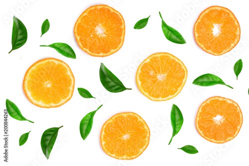 Slices of orange or tangerine decorated with green leaves isolated on white background, top view. Fruit composition