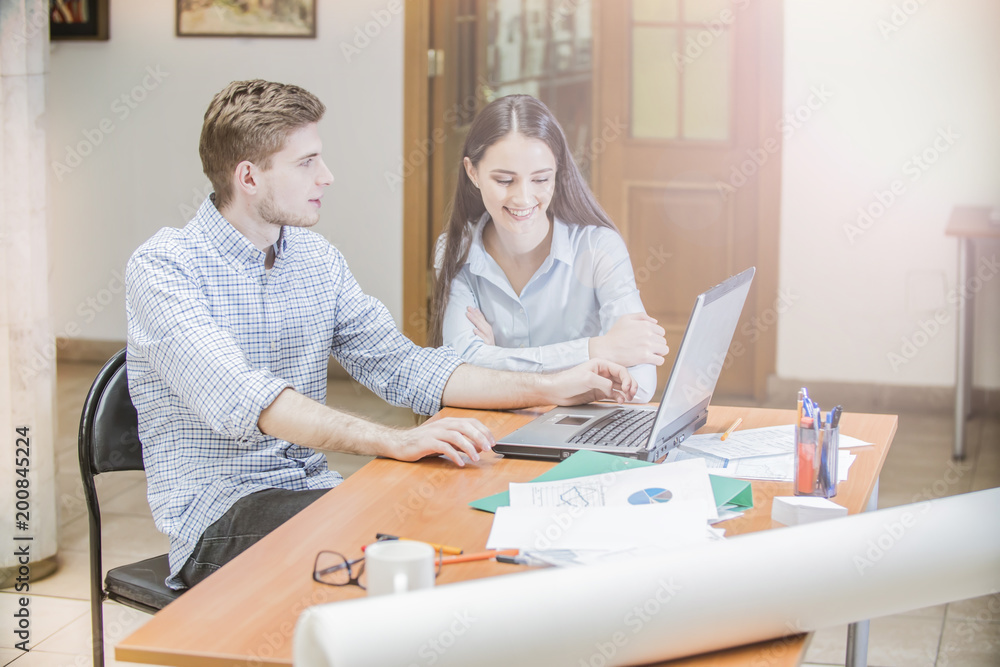 the guy and the girl on the laptop, students work and study, young businessmen the guy and the girl on the laptop, students work and study, young businessmen