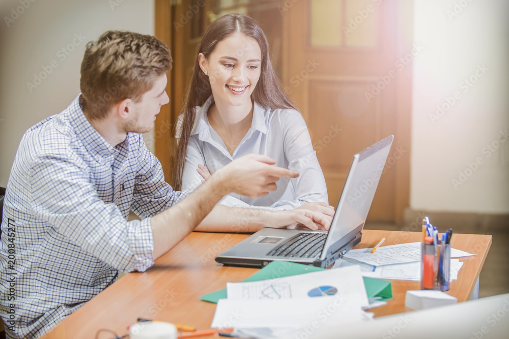 the guy and the girl on the laptop, students work and study, young businessmen the guy and the girl on the laptop, students work and study, young businessmen