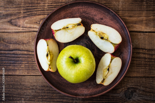 green apple on a plate on wooden background