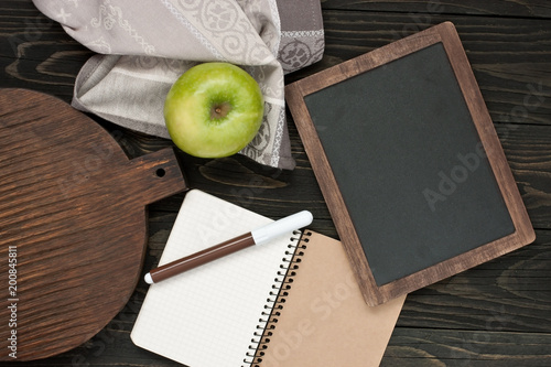 Blank notebook and pen for recipe on wooden kitchen table