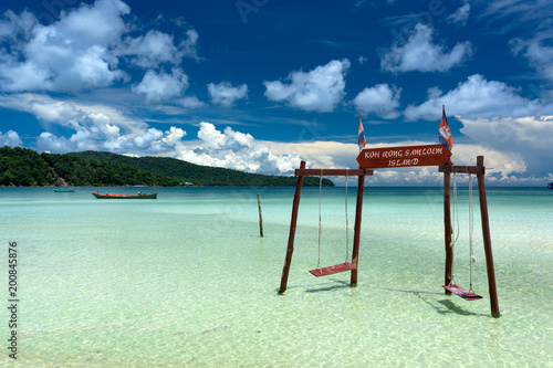 Original and stylish wooden swing standing in the water at the beach of Koh Rong Samloem tropical island. Saracen Bay, Cambodia. 