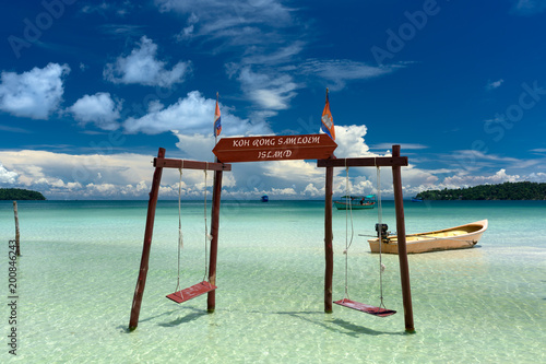 Original and stylish wooden swing standing in the water at the beach of Koh Rong Samloem tropical island. Saracen Bay, Cambodia.  photo