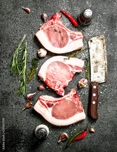 Raw pork steak with a sprig of rosemary and spices.